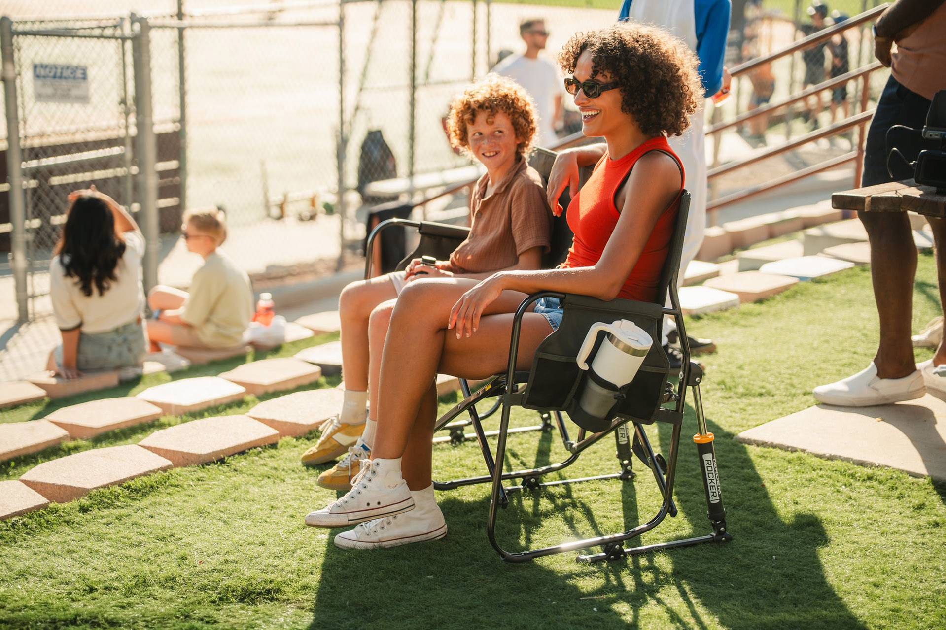 Two women sitting on a tandem rocker outdoors.