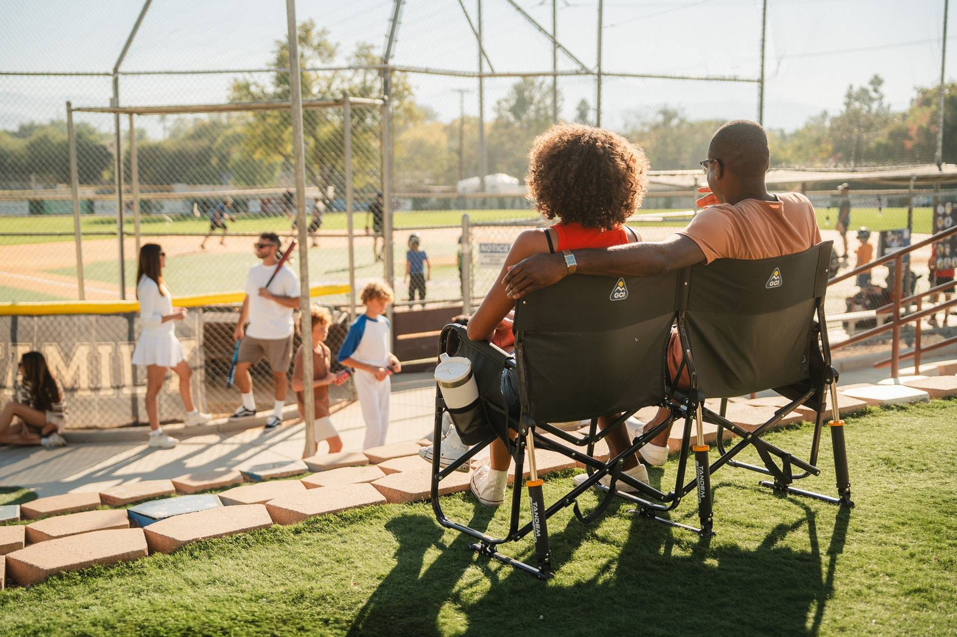 Couple relaxing on a tandem rocker outdoors.