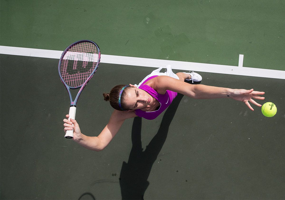 Woman Preparing To Serve On Tennis Court