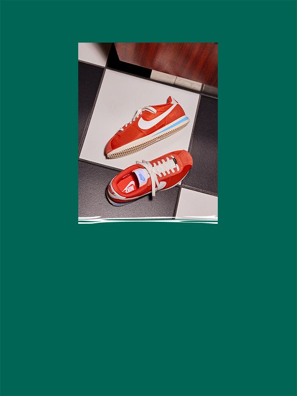 Orange Nike shoes on a black and white floor.